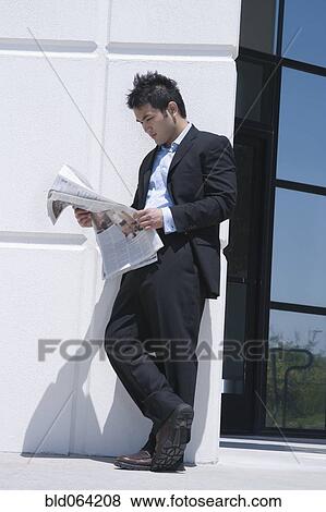 Asian businessman reading newspaper outdoors View Large Photo Image Stock Photo - Asian businessman reading newspaper outdoors. Fotosearch