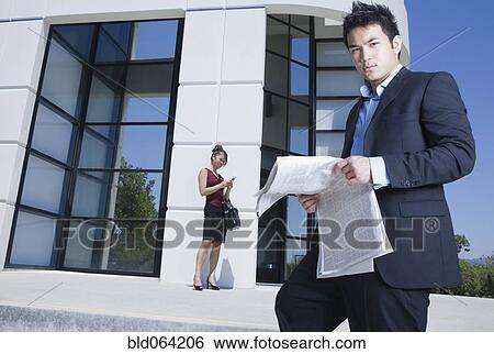 Asian businessman reading newspaper outdoors View Large Photo Image Stock Photograph - Asian businessman reading newspaper outdoors. Fotosearch