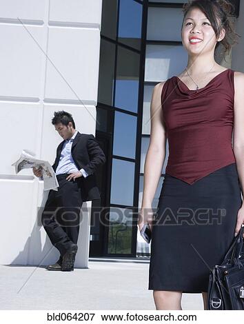 Stock Photo - Asian businesswoman standing outdoors with briefcase. Fotosearch