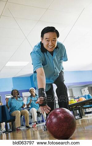 Stock Photo - Asian man bowling. Fotosearch