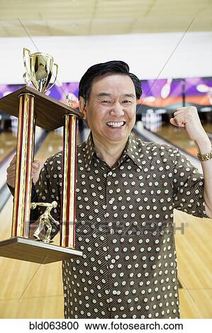 Asian man with bowling trophy View Large Photo Image Stock Image - Asian man with bowling trophy. Fotosearch