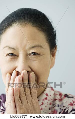 Asian woman covering her mouth View Large Photo Image Stock Image - Asian woman covering her mouth. Fotosearch