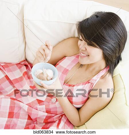 Picture - Asian woman eating ice cream. Fotosearch