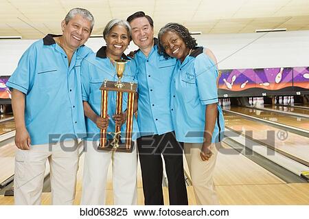 Stock Photography - Bowling team with trophy in bowling alley. Fotosearch