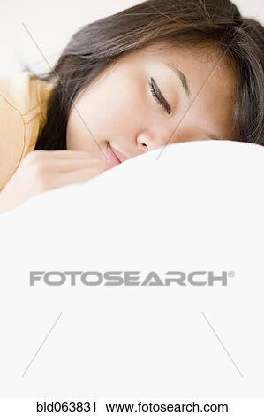Stock Image - Close up of Asian woman sleeping. Fotosearch