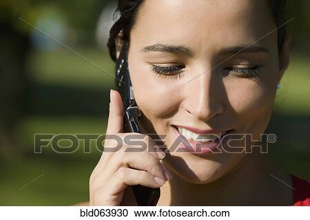 Stock Image - Close up of Hispanic woman talking on cell phone. Fotosearch