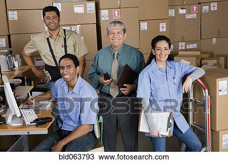 Stock Image - Co-workers in shipping office. Fotosearch