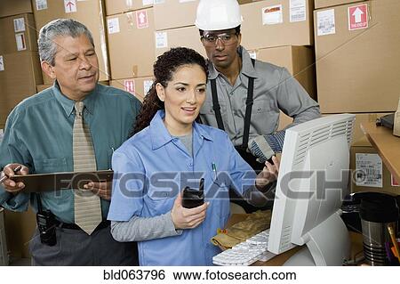 Stock Photograph - Co-workers in shipping office. Fotosearch