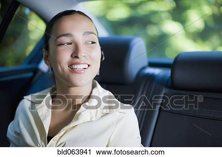 Stock Image - Hispanic businesswoman with hands-free cell phone device. Fotosearch
