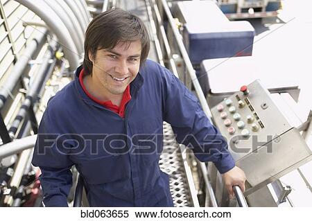 Stock Photography - Hispanic man working in bottling factory. Fotosearch