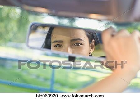 Hispanic woman adjusting rear view mirror in car View Large Photo Image Stock Image - Hispanic woman adjusting rear view mirror in car. Fotosearch