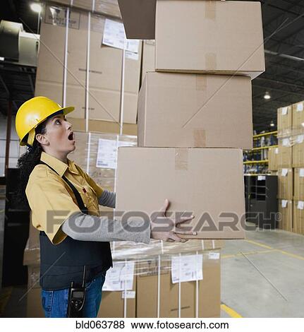 Hispanic woman carrying stack of boxes View Large Photo Image Stock Photo - Hispanic woman carrying stack of boxes. Fotosearch