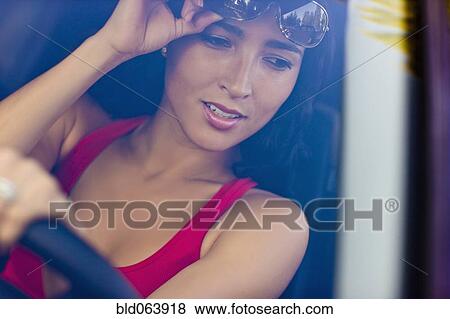 Stock Photo - Hispanic woman driving car. Fotosearch