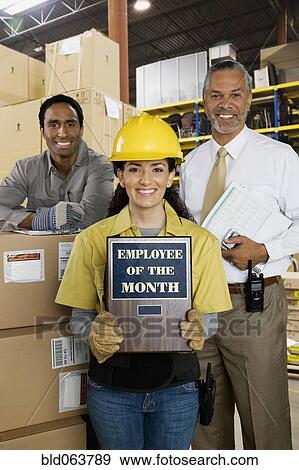 Hispanic woman holding Employee of the Month plaque View Large Photo Image Stock Photo - Hispanic woman holding Employee of the Month plaque. Fotosearch