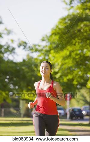 Hispanic woman jogging in park View Large Photo Image Picture - Hispanic woman jogging in park. Fotosearch