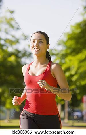 Stock Photography - Hispanic woman jogging in park. Fotosearch