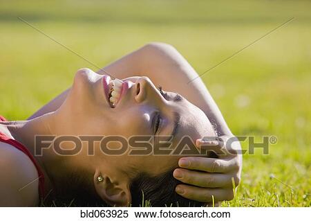 Hispanic woman laying in grass smiling View Large Photo Image Stock Photography - Hispanic woman laying in grass smiling. Fotosearch
