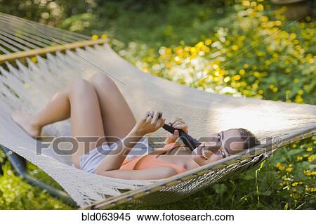 Stock Photography - Hispanic woman laying in hammock. Fotosearch