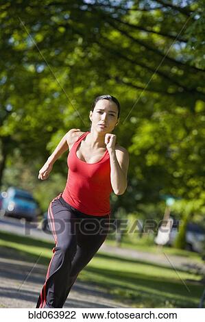 Stock Image - Hispanic woman running in park. Fotosearch