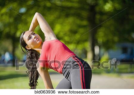 Stock Photograph - Hispanic woman stretching in park. Fotosearch