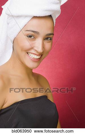 Stock Image - Hispanic woman with hair wrapped in towel. Fotosearch