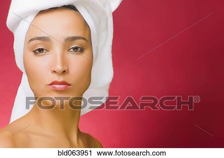 Stock Image - Hispanic woman with hair wrapped in towel. Fotosearch