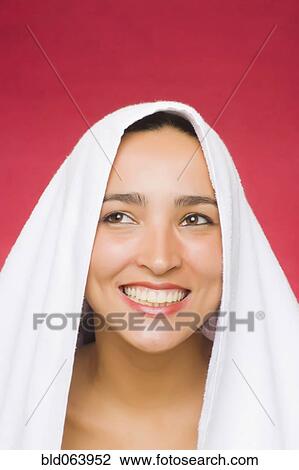 Stock Image - Hispanic woman with hair wrapped in towel. Fotosearch