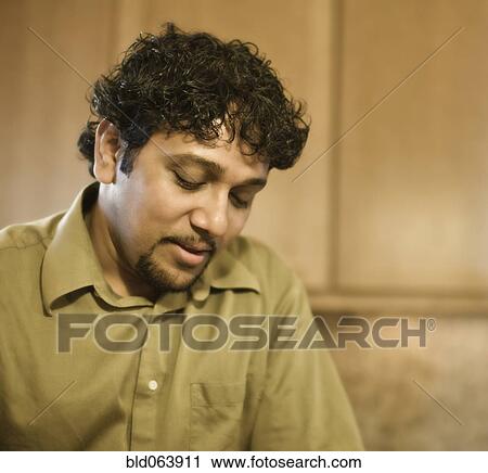 Stock Image - Indian man with goatee looking down. Fotosearch