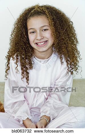 Stock Image - Mixed race girl in nightgown. Fotosearch