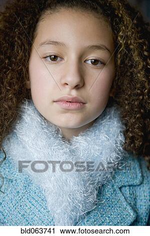 Stock Image - Mixed race girl in scarf and jacket. Fotosearch