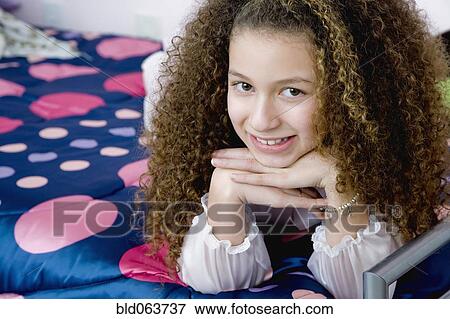 Mixed race girl laying on bed in bedroom View Large Photo Image Stock Photo - Mixed race girl laying on bed in bedroom. Fotosearch