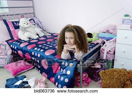 Mixed race girl laying on bed in bedroom View Large Photo Image Stock Photograph - Mixed race girl laying on bed in bedroom. Fotosearch