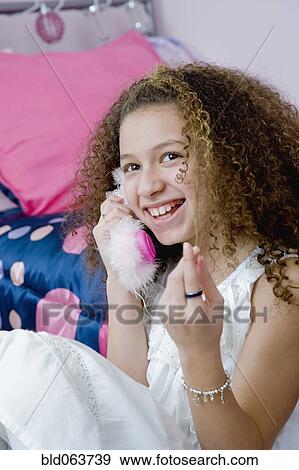 Stock Photo - Mixed race girl talking on toy telephone. Fotosearch