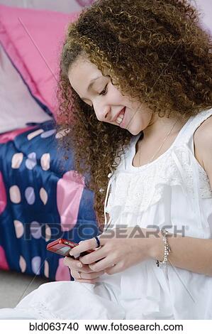 Mixed race girl text messaging on cell phone View Large Photo Image Stock Image - Mixed race girl text messaging on cell phone. Fotosearch
