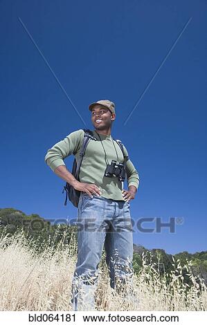 Mixed race man backpacking on hillside View Large Photo Image Stock Image - Mixed race man backpacking on hillside. Fotosearch