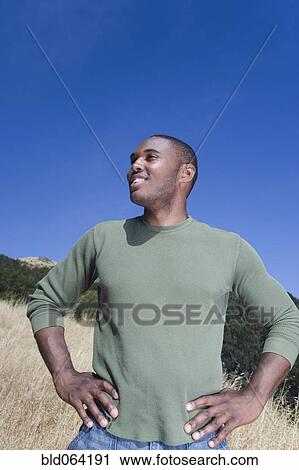 Stock Image - Mixed race man standing in rural area. Fotosearch