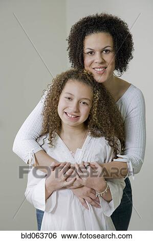 Mixed race mother and daughter hugging View Large Photo Image Stock Photograph - Mixed race mother and daughter hugging. Fotosearch