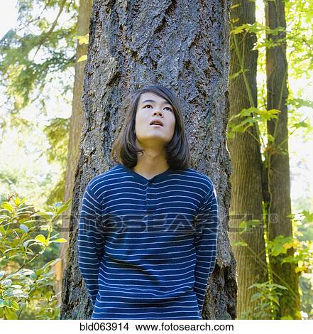 Picture - Mixed race teenage boy in forest. Fotosearch