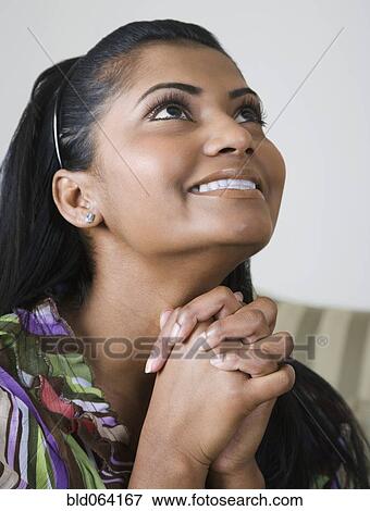 Stock Photo - Mixed race woman praying. Fotosearch