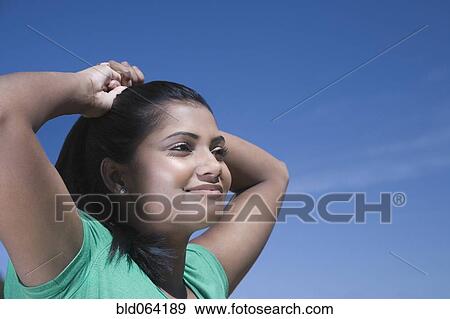 Stock Photo - Mixed race woman with hands on head. Fotosearch