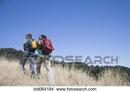 Multi-ethnic couple backpacking in rural area View Large Photo Image Picture - Multi-ethnic couple backpacking in rural area. Fotosearch