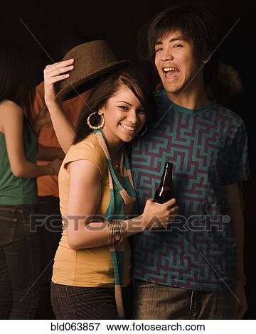 Stock Photo - Multi-ethnic couple drinking in nightclub. Fotosearch