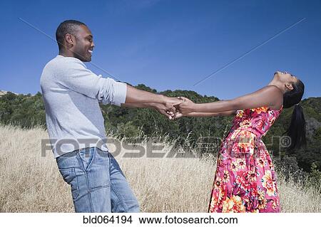 Multi-ethnic couple holding hands in rural area View Large Photo Image Picture - Multi-ethnic couple holding hands in rural area. Fotosearch