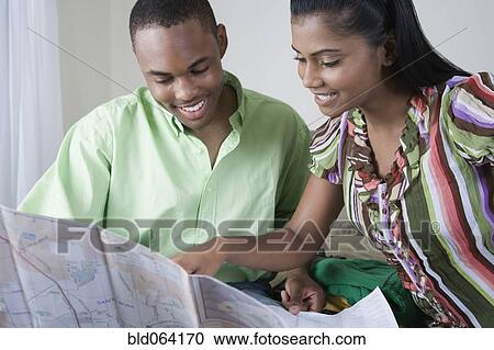 Stock Image - Multi-ethnic couple looking at map. Fotosearch