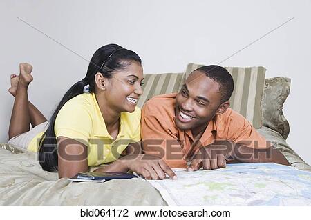 Stock Image - Multi-ethnic couple looking at map. Fotosearch