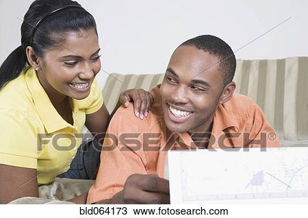 Stock Image - Multi-ethnic couple looking at map. Fotosearch