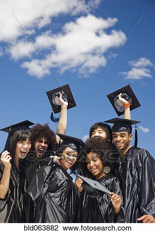Stock Image - Multi-ethnic friends celebrating graduation. Fotosearch