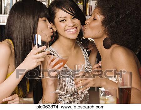 Picture - Multi-ethnic friends drinking in nightclub. Fotosearch