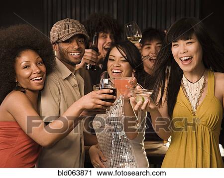 Multi-ethnic friends drinking in nightclub View Large Photo Image Stock Image - Multi-ethnic friends drinking in nightclub. Fotosearch