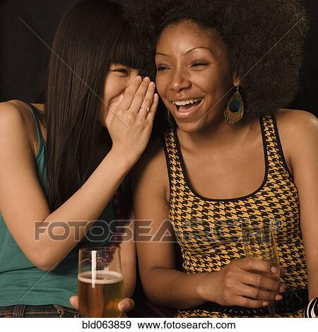 Stock Photo - Multi-ethnic friends drinking in nightclub. Fotosearch